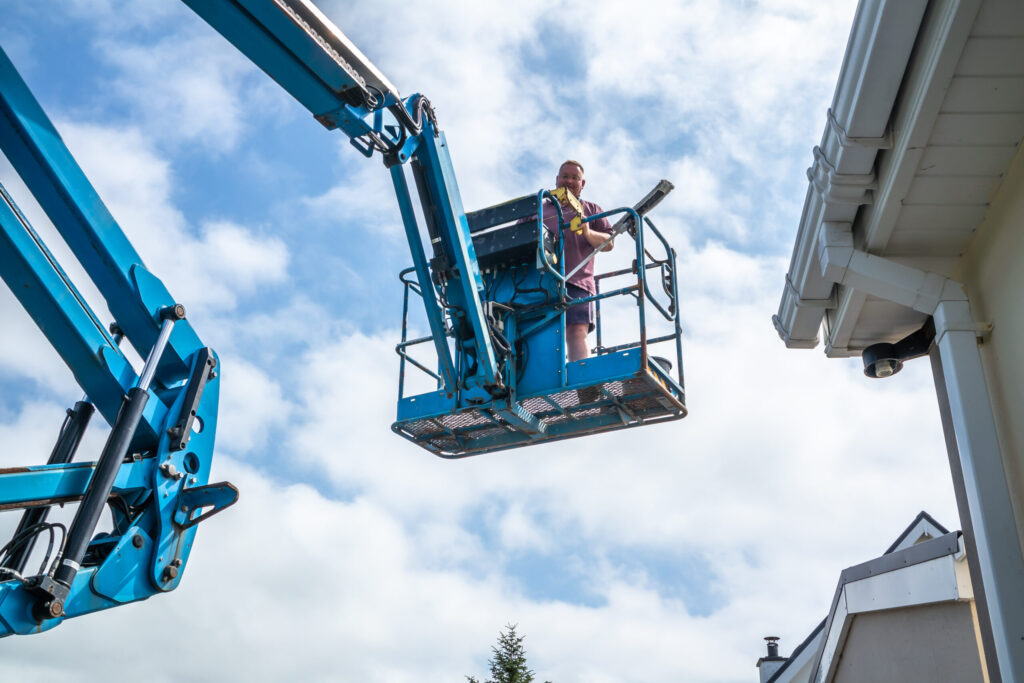 cherry picker equipment used for gutter cleaning and repair on commercial building