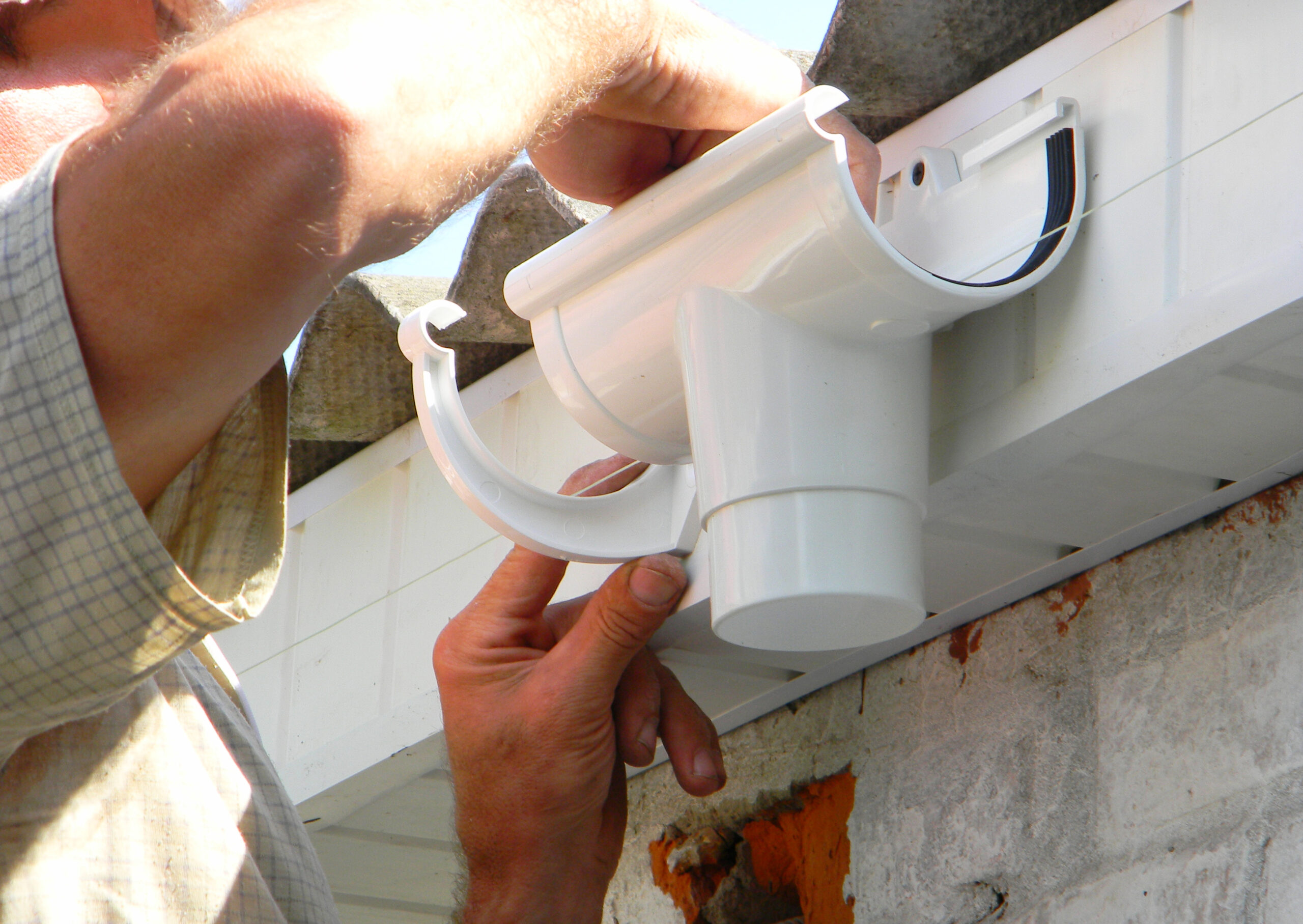 man repairing a gutter joint